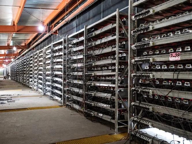 A miner inspecting rows of ASIC miners in a large mining farm.